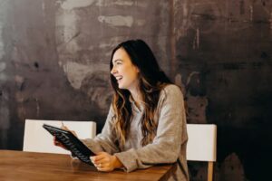 Femme souriante avec tablette - coaching individuel – formation gestion du stress – Audrey Martin Coaching