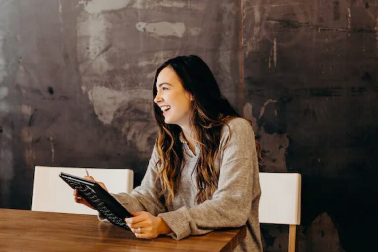 Femme souriante avec tablette - coaching individuel – formation gestion du stress – Audrey Martin Coaching
