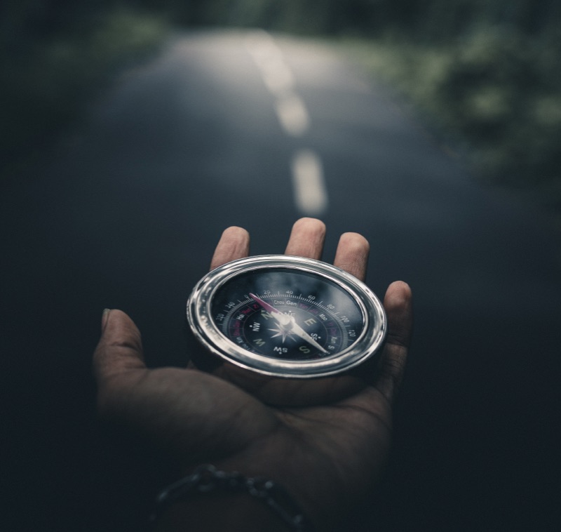 Main tenant une boussole sur route - coaching individuel – formation – Audrey Martin Coaching