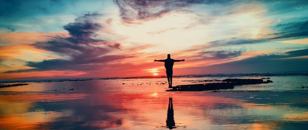 Silhouette bras écartés au coucher du soleil - coaching professionnel Landes – coaching en visio – Audrey Martin Coaching